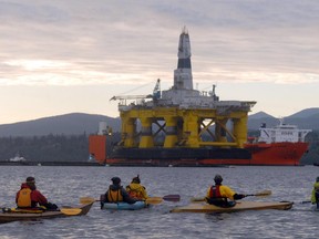 Protesters in kayaks paddle out to meet the Arctic offshore oil rig Polar Pioneer piggybacked atop the cargo deck vessel Blue Marlin as it arrives at Port Angeles, Wash., on Friday, April 17, 2015. The platform will eventually be towed to Alaska for exploratory drilling in the Chukchi Sea after being outfitted in Seattle. The protesters say they will have larger demonstrations in Seattle in May.