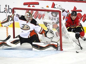 Calgary Flames left winger Johnny Gaudreau stretched for the puck as he looked to knock it into the net while Anaheim Ducks defenceman Simon Despres and goalie Frederik Andersen looked to stop him during first period NHL playoff action at the Scotiabank Saddledome on May 8, 2015.