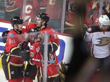 Calgary Flames centre Sean Monahan celebrated with teammates Jiri Hudler and Johnny Gaudreau after scoring the first Flames goal of the game against the Anaheim Ducks during first period NHL playoff action at the Scotiabank Saddledome on May 8, 2015.