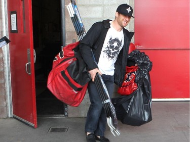 Calgary Flames player defenceman Dennis Wideman carried his bag and sticks from the arean during the annual garbage bag day at the Scotiabank Saddledome on May 12, 2015.