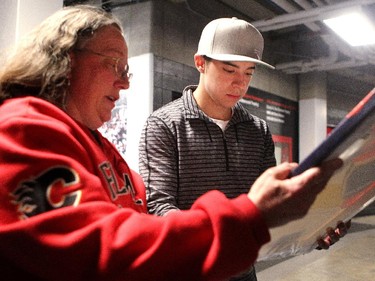Calgary Flames player left winger Johnny Gaudreau signed a print of himself for season ticket holder and fan Jeannette Wilson during the annual garbage bag day at the Scotiabank Saddledome on May 12, 2015.