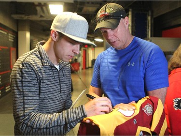 Calgary Flames player left winger Johnny Gaudreau signed a jersey for media member David Moir during the annual garbage bag day at the Scotiabank Saddledome on May 12, 2015.