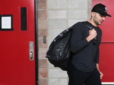 Calgary Flames player defencemand Mark Giordano carried a garbage bag out of the arena during the annual garbage bag day at the Scotiabank Saddledome on May 12, 2015.