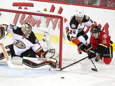 Calgary Flames left winger Johnny Gaudreau stretched for the puck as he looked to knock it into the net while Anaheim Ducks defenceman Simon Despres and goalie Frederik Andersen looked to stop him during first period NHL playoff action at the Scotiabank Saddledome on May 8, 2015.