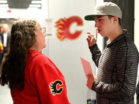 Calgary Flames rookie Johnny Gaudreau chats with season ticket holder and fan Jeannette Wilson during the club's annual garbage bag day at the Scotiabank Saddledome on Tuesday.