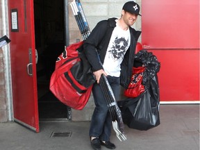 Calgary Flames defenceman Dennis Wideman, without a playoff beard anymore, carries his bag and sticks from the arena during the annual garbage bag day at the Scotiabank Saddledome on Tuesday.