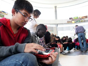 Don Bosco Grade 7 student Chris Lo works on an iPad with classmates during a class at the Calgary Stampede which looked at agricultural sustainability on May 14, 2015.