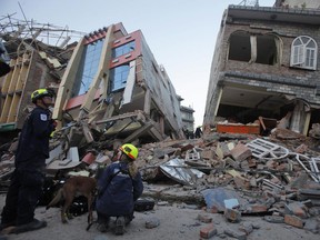 USAID rescue workers inspect the site where buildings collapsed in an earthquake in Kathmandu, Nepal, Tuesday, May 12, 2015. A major earthquake hit a remote mountainous region of Nepal on Tuesday, triggering landslides and toppling buildings less than three weeks after the country was ravaged by another deadly quake.