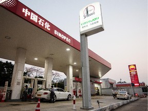 Employees refuel a car at a Sinopec gas station in Hong Kong.