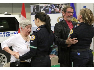 Marilyn Stallworthy and her husband Bob greet EMT Janelle Duncan, left and Paramedic Brynna Jesse, right, who helped save her life almost two years ago in Calgary.