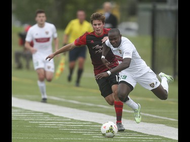 Portland Timbers striker Benjamin White, left, attempts to push past Foothills FC defender Bradley Kamdem Fewo at Hellard Field in Calgary on Tuesday, June 2, 2015. The Foothills FC led the Portland Timbers, 1-0, at the first half of regular season Premier Development League play.