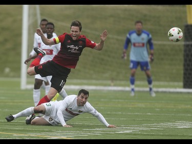 Portland Timbers midfielder Todd Wharton, centre, trips over Foothills FC defender Massimo Megna at Hellard Field in Calgary on Tuesday, June 2, 2015. The Foothills FC led the Portland Timbers, 1-0, at the first half of regular season Premier Development League play.