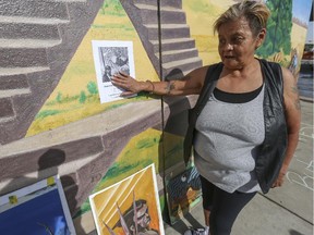 Mimi McCauley, a friend of Ryan Delve's, tapes a photograph of Delve on one of his murals, so others could see and remember him during this memorial under the fifth avenue flyover.