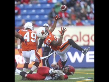 B.C. Lion defensive back Darious Lane, top, is taken down by Calgary Stampeder running back Charlie Power at McMahon Stadium in Calgary on Friday, June 12, 2015. The Calgary Stampeders tied the B.C. Lions, 6-6, at the end of the half in an pre-season exhibition game.