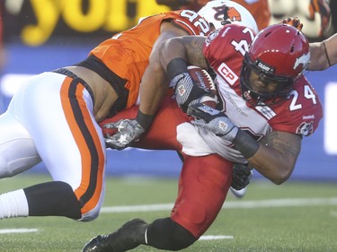 B.C. Lion defensive lineman Alex King, left, takes down Calgary Stampeder running back Keith Tosto at McMahon Stadium in Calgary on Friday, June 12, 2015. The Calgary Stampeders won over the B.C. Lions, 20-6, at the end of the the first pre-season exhibition game for the team.