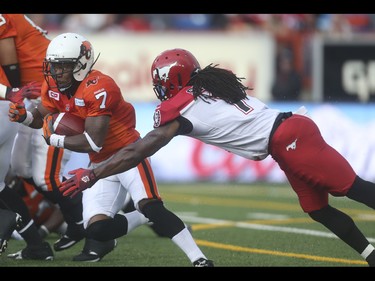B.C. Lion wide receiver Rickey Galvin, left, evades through the Calgary Stampeder defence at McMahon Stadium in Calgary on Friday, June 12, 2015. The Calgary Stampeders tied the B.C. Lions, 6-6, at the end of the half in an pre-season exhibition game.