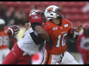 B.C. Lion quarterback Jonathon Jennings, right, is sacked by Calgary Stampeder linebacker Deron Mayo at McMahon Stadium in Calgary on Friday, June 12, 2015. The Calgary Stampeders tied the B.C. Lions, 6-6, at the end of the half in an pre-season exhibition game.