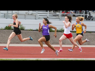 Janelle Khan-Nielsen, centre left, along with other runners in the women 100 metre dash open race past largely silent stands in the Caltaf Track Classic in Calgary on Saturday, June 20, 2015.