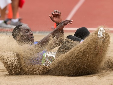 Gee-ef Nkwonta lands sideways into a sand pit white competing in the long jump in the Caltaf Track Classic in Calgary on Saturday, June 20, 2015.