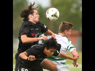 Washington Crossfire players Logen Flem, left, and Jose Ocampo attempt to push Foothills FC player Dominic Russo out of a header at Hellard Field in Calgary on Sunday, June 21, 2015.