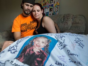 Brian and Kyla Woodhouse look at a t-shirt with a photo of their daughter Meika Jordan on it in their home in Calgary, on June 25.