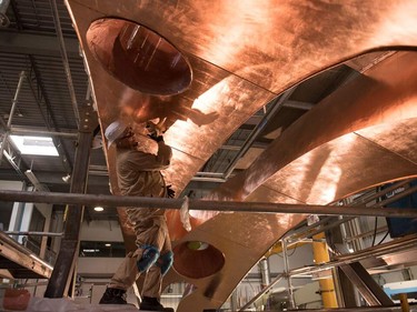 Yahgulanaas took a safety course before being allowed onto the steel fabrication floor; he signed off on every process from start to finish. Here, he goes over the copper leaf, flattening the edges to ensure it’s in good contact witih the 
stainless steel.