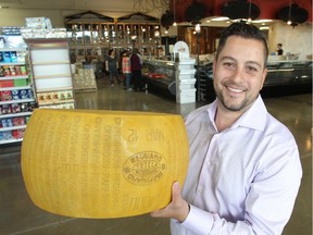 Gino Marghella, store manager, hoists the big cheese at the soon to open Italian Centre Shop. The store has three popular locations in Edmonton and this is its first entry into Calgary.