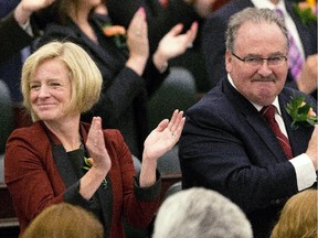 Premier Rachel Notley and Infrastructure Minister Brian Mason applaud after the speech from the throne in Edmonton.
