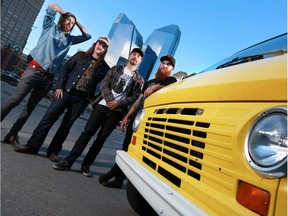 Calgary band MANcub from left, Sean Doherty, guitar, Kevin Ross, drums, Dan Kneeshaw, bass, and Trenton Bullard, vocals, stand next to their 1970 Ford van in Calgary's beltline on Monday June 15, 2015.