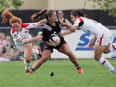 Team Canada's Alexandra Tessier, left, and Amanda Thornborough tackle  New Zealand's Stacey Waaka during their Rugby Canada Super Series game at Calgary Rugby Park on Saturday June 27, 2015.
