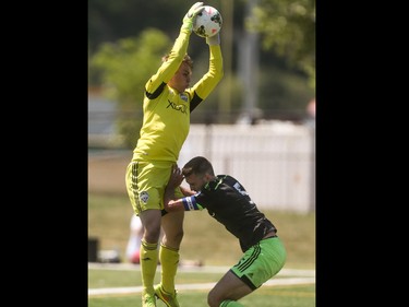 Seattle Sounders goalkeeper Troy Perkins, left, is bowled into by Andy Rose at Hellard Field in Calgary on Sunday, June 28, 2015. Foothills FC lost to the Seattle Sounders, 4-0, in regular season Premiere Development League play.