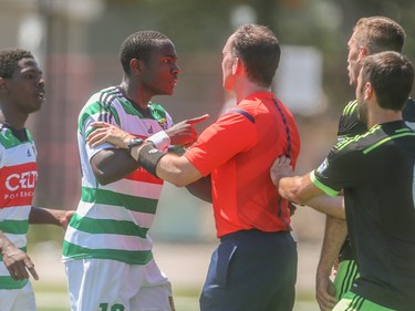 Foothills FC defender Bradley Kamdem Fewo, centre, argues with a referee after a highly charged penalty is called at Hellard Field in Calgary on Sunday, June 28, 2015. Foothills FC lost to the Seattle Sounders, 4-0, in regular season Premiere Development League play.
