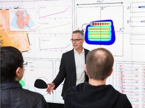 Professor David Eaton with students from his research group reviewing microseismic data in the Visualization Studio in the Taylor Family Digital Library.