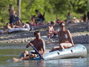 Samantha Swereda and Cassidy Bruce soak up the sunshine on their raft as they approach the 25th Avenue bridge in Mission Monday June 8, 2015, a day of record setting mid 30's Celcius temperatures. The rocky shoal on the west bank in the bend attracted dozens of sunworshippers.