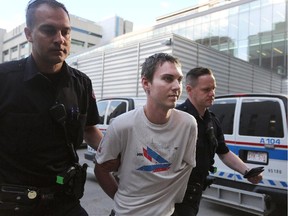 A suspect in a hit and run is taken into the arrest processing unit in downtown Calgary on June 10, 2015.