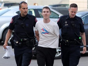Joshua Cody Mitchell, is pictured being taken into the arrest processing unit in Calgary on June 10, 2015.
