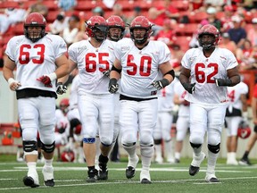 Calgary Stampeders offensive linemen Pierre Lavertu, left, Dan Federkeil, Shane Bergman, Spencer Wilson and Edwin Harrison, head out onto the field during the team's intra-squad game last month. Both Federkeil and Harrison are lost with broken legs, so the Stamps are scrambling to add depth to the line.