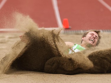 Hendric Tronsson sends waves of sand crashing after landing a long jump in the Caltaf Track Classic in Calgary on Saturday, June 20, 2015.