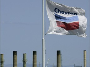 The Chevron flag flies over a refinery in California. The company is confirming a restructuring of its Canadian arm.