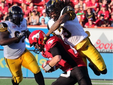 Calgary Stampeders Bo Levi Mitchell is sacked by Hamilton Tiger-Cats Johnny Sears Jr.  during their season opener at McMahon Stadium, on June 26, 2015.