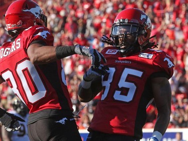 Calgary Stampeders Eric Rogers and Joe West celebrate a touchdown against the Hamilton Tiger-Cats during their season opener at McMahon Stadium, on June 26, 2015.