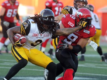 Tit for tat. Calgary Stampeders Jon Cornish gets a face rub from the Hamilton Tiger-Cats Johnny Sears Jr. during their season opener at McMahon Stadium, on June 26, 2015.