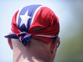 In this July 9, 2011 file photo, a man wears a confederate flag bandana on his head at the 15th annual Redneck Games in East Dublin, Ga. Retailers in Alberta and all over North America are removing products with the flag from their stores following the shooting of nine black churchgoers in Charleston, S.C. last week.
