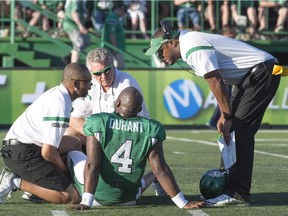 Saskatchewan Roughriders head coach Corey Chamblin, right, comes to the field to check on his quarterback Darian Durant as they take on the Winnipeg Blue Bombers during the second quarter of CFL football action in Regina, Sask., Saturday, June 27, 2015.