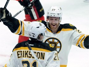 Boston Bruins' Dougie Hamilton, back skates towards teammate Loui Eriksson to congratulate him on his goal during second period NHL hockey action in Ottawa on March 10, 2015. The Boston Bruins dealt defenceman Dougie Hamilton to the Calgary Flames for three 2015 draft picks Friday.