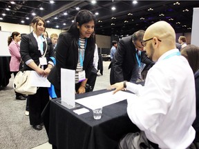 Job seeker Sonal Ghag, centre left, spoke to Bowen Business Development Manager Chintan Ahluwalia, right, during the Global Energy Career Expo at the Telus Convention Centre on June 10, 2015.
