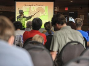 Brad Larson, with the City's water resources department, points at a powerpoint slide and explains to Sunnyside community members gathered at the Hillhurst Sunnyside Community Centre about the City's drainage improvement plans for their area in Calgary, on June 24, 2015.