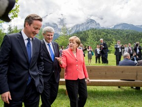 German Chancellor Angela Merkel talks to Prime Minister Stephen Harper and British Prime Minister David Cameron at the G7 summit in southern Germany on Monday.