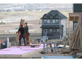 Construction workers build homes  in northwest Calgary.