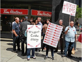 A small group protests outside a Tim Hortons in Calgary's beltline after the company pulled an in-store Enbridge ad in response to an online petition.